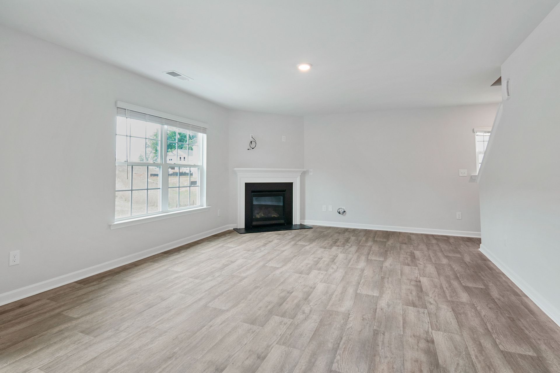 Bright and spacious living room featuring a modern fireplace and parquet flooring, ideal for contemporary interiors.